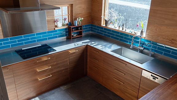 木目が美しい扉とスタイリッシュなステンレスカウンターのL型キッチン